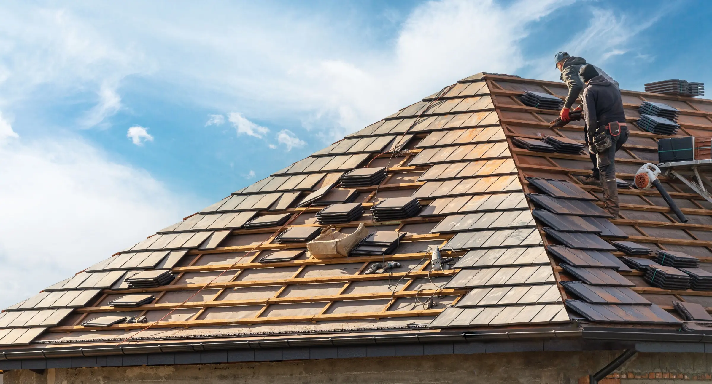A man is working on the roof replacement of a house.
